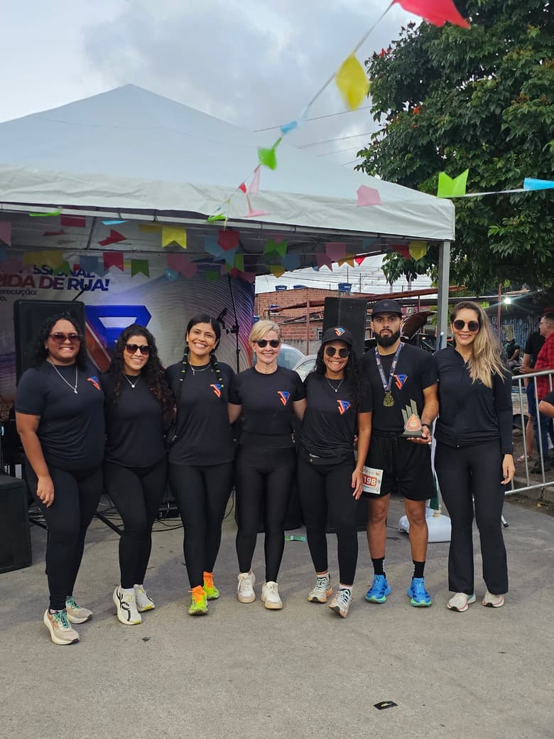 Equipe de staff da JR, de camiseta preta, reunida na arena da Arraiá Run